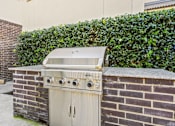 Thumbnail 13 of 23 - Built in gas grill with brick surround and hedge backdrop at Matilda at Lower Greenville Apartments, Dallas, 75206