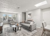 Thumbnail 6 of 29 - A living room with a grey couch and a coffee table.