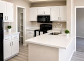 Thumbnail 2 of 26 - Modern kitchen with white cabinetry and island at Cortina Apartments, Phoenix