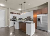 Thumbnail 8 of 23 - Contemporary kitchen with granite countertops and pendant lights at Matilda at Lower Greenville Apartments, Dallas, TX