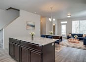 Thumbnail 9 of 18 - A modern kitchen with a large island and a painting on the wall.