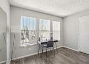 Thumbnail 7 of 29 - A room with a desk and chair in front of a window with blinds.