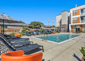 Thumbnail 15 of 25 - Resort style pool with lounge chairs and sundeck at Avion at West Lemmon Apartments, Dallas, Texas