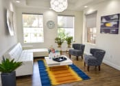 Thumbnail 14 of 26 - Modern White Leather Couch sits opposite 2 patterned blue chairs in Main Lobby