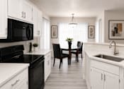 Thumbnail 1 of 26 - Modern kitchen with white cabinets and black appliances at Cortina Apartments, Phoenix, AZ