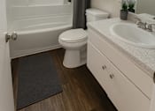 Thumbnail 9 of 17 - A white bathroom with a toilet, sink, and bathtub.