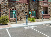 Thumbnail 14 of 25 - A parking lot with a charging station and a building in the background.