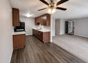 Thumbnail 1 of 22 - A kitchen with wooden cabinets and a black fridge.