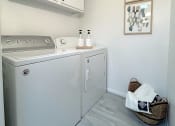 Thumbnail 11 of 25 - a small laundry room with a washer and dryer and white cabinets