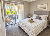 Thumbnail 8 of 23 - Bedroom with balcony access and ceiling fan at Gentrys Walk Apartments, Mesa