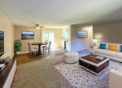 Thumbnail 4 of 12 - A living room with a white couch, a coffee table, and a ceiling fan.