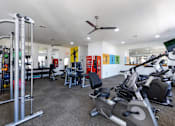 Thumbnail 22 of 24 - A gym with a variety of equipment including treadmills, weights, and exercise machines.