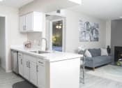 Thumbnail 3 of 25 - an open kitchen and living room with a couch and a sink