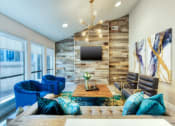 Thumbnail 2 of 25 - Clubhouse Lounge with Comfortable Seating, Rock Covered Wall with a TV, and Artsy Overhead Pendant Lighting at Enclave at Paradise Valley, Phoenix, AZ