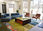 Thumbnail 16 of 24 - A living room with a blue couch and a coffee table.
