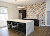 Thumbnail 20 of 24 - A kitchen with a marble countertop and a patterned wallpaper.
