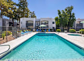 Thumbnail 16 of 20 - A swimming pool with a blue tiled edge and a white fence around it.