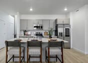 Thumbnail 20 of 24 - A modern kitchen with a dining table set for two.