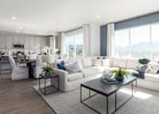 Thumbnail 4 of 28 - A modern living room with a white sofa, a black coffee table, and a kitchen area in the background.