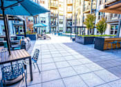 Thumbnail 9 of 29 - A patio with tables and chairs is surrounded by buildings.at The Ace in Richmond, Virginia