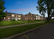 Thumbnail 4 of 26 - A long building with a green lawn in front.
