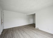 Thumbnail 16 of 26 - A room with a wooden floor and white walls.