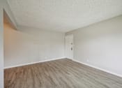 Thumbnail 10 of 26 - A room with a wooden floor and a white door.