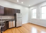 Thumbnail 3 of 7 - A kitchen with wooden floors and stainless steel appliances.