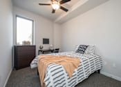 Thumbnail 9 of 11 - A bedroom with a bed, nightstand, and window.
