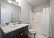 Thumbnail 11 of 11 - A white bathroom with a sink, toilet, and shower.