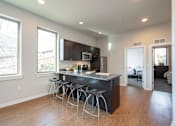 Thumbnail 6 of 11 - A kitchen with a bar stool and a counter.