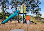 Thumbnail 12 of 14 - A playground with a blue and yellow slide.