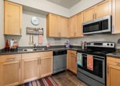 Thumbnail 12 of 12 - a kitchen with wooden cabinets and stainless steel appliances and a microwave