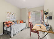 Thumbnail 9 of 12 - a bedroom with a bed and a desk and a window