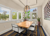 Thumbnail 4 of 12 - a dining room with a table and chairs and windows