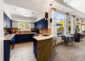 Thumbnail 2 of 15 - a kitchen with blue cabinets and a table with chairs