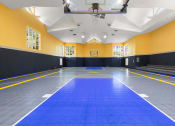 Thumbnail 4 of 15 - a large gym with a blue floor and a scoreboard