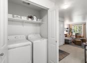 Thumbnail 14 of 15 - a white laundry room with two washes and a dryer