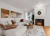 Thumbnail 13 of 15 - A cozy living room with a fireplace and a wreath on the mantle.