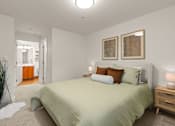 Thumbnail 15 of 15 - A bedroom with a bed, nightstands, and two framed pictures on the wall.