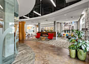 Thumbnail 18 of 20 - the lobby of an office with a fireplace and plants