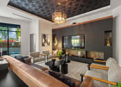 Thumbnail 15 of 27 - a living room with a leather couch and a television