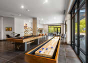 Thumbnail 16 of 27 - a game room with a shuffleboard table and a pool table