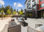 Thumbnail 23 of 27 - an outdoor patio with couches and tables in front of a building
