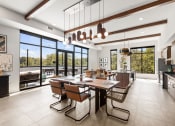 Thumbnail 17 of 27 - a dining room with a long wooden table and chairs and large windows
