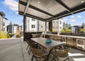Thumbnail 22 of 27 - a communal patio with a table and chairs and a bar and buildings