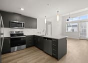 Thumbnail 9 of 27 - a renovated kitchen with black cabinets and a white counter top