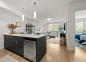 Thumbnail 8 of 27 - a kitchen with an island and a bedroom in the background