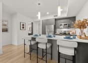 Thumbnail 2 of 27 - a kitchen with a large island with three stools