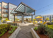 Thumbnail 11 of 20 - A patio with a table and chairs under a roof.